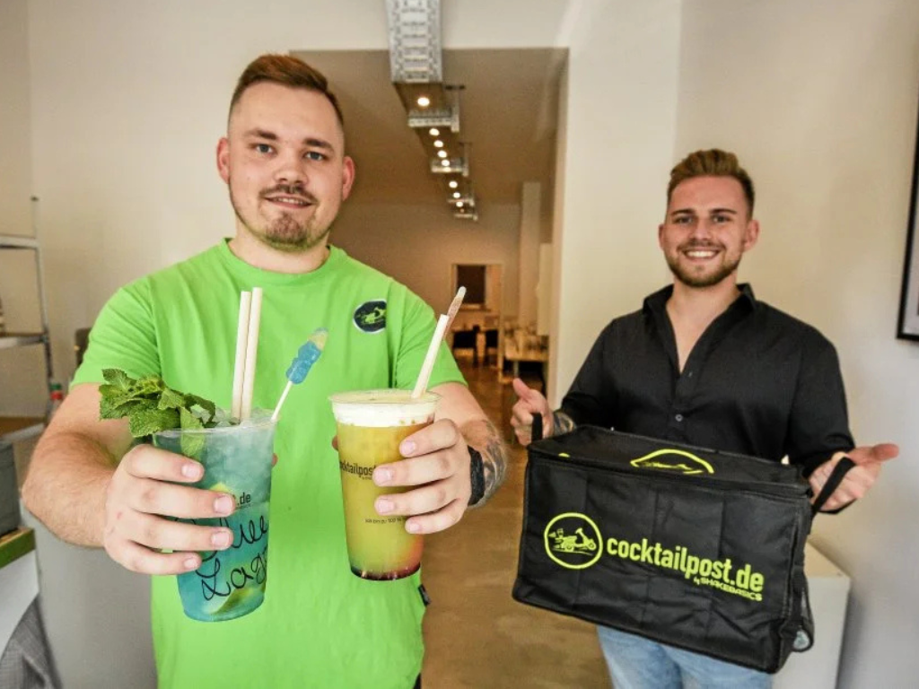 2 Barkeeper halten Cocktail in der Hand beim Cocktailtaxi