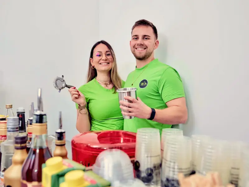 2 Barkeeper lächeln in Kamera beim Cocktailkurs